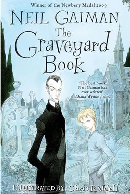 A vampire like man in black and a little blonde boy in blue, stand in a graveyard.